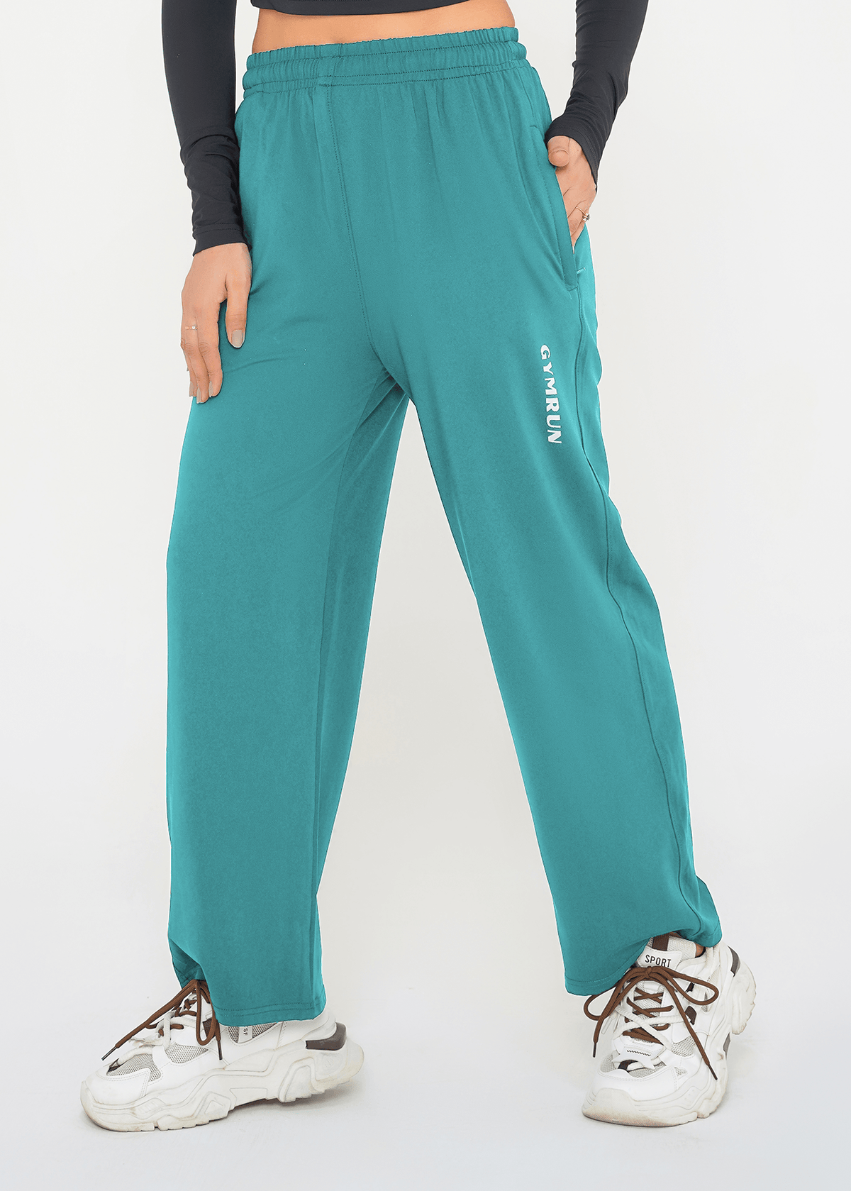 Teal sweatpants with a brand logo worn by a person on a white background