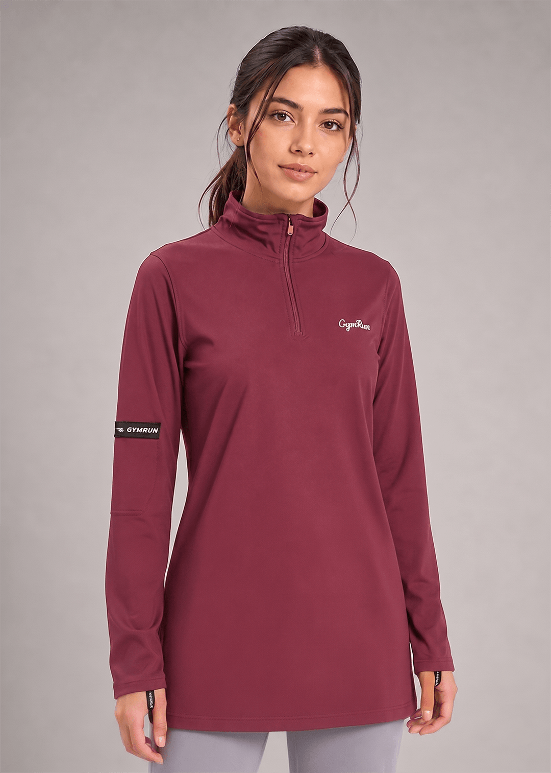 A woman modeling a long-sleeve quarter-zip pullover in a deep burgundy color. The pullover features a small white 'Gymrun' logo on the left chest and a black sleeve patch with white text that reads 'Gymrun'.