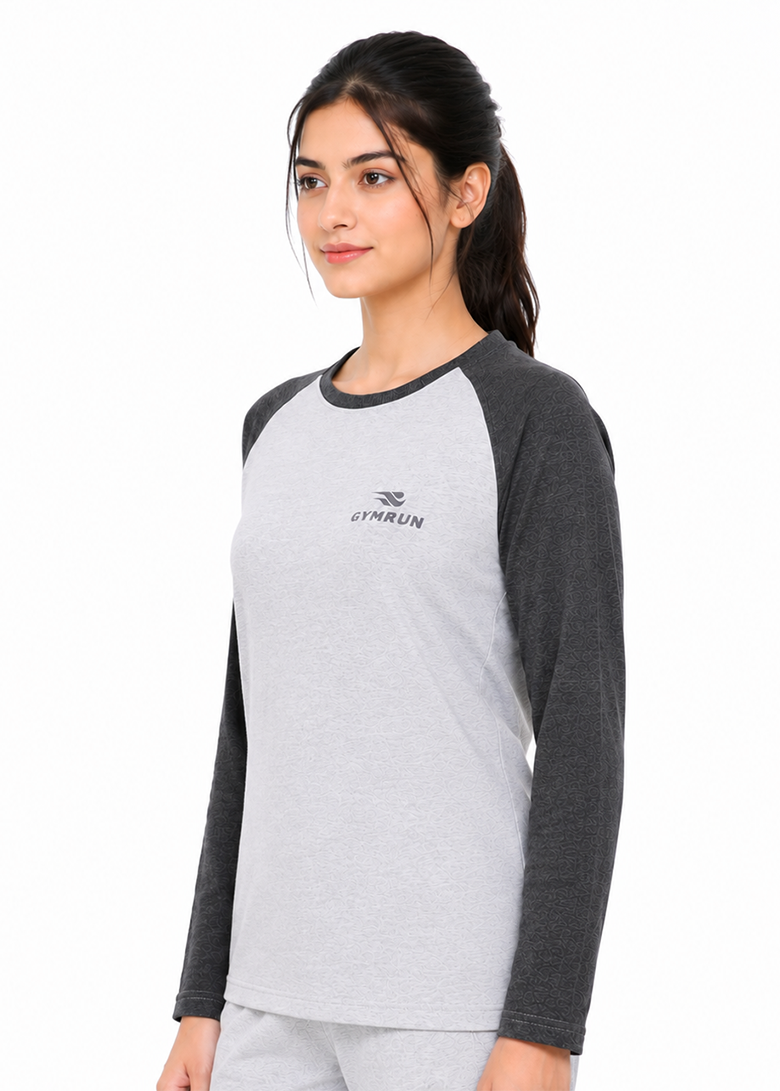 A woman modeling a light gray and dark gray raglan long-sleeve t-shirt with a small black GYMRUN logo on the left chest, set against a plain white background.