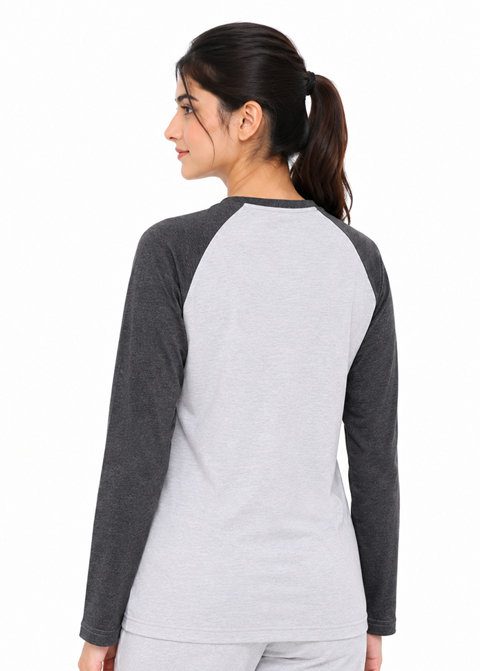 A woman shown from the back wearing a long-sleeve raglan baseball shirt in light gray and dark gray, paired with matching light gray pants, against a plain white background.