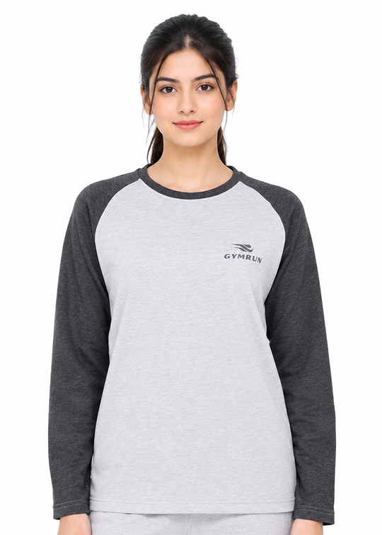 A woman modeling a light gray and dark gray raglan long-sleeve t-shirt with a small black GYMRUN logo on the left chest, shot against a plain white background.