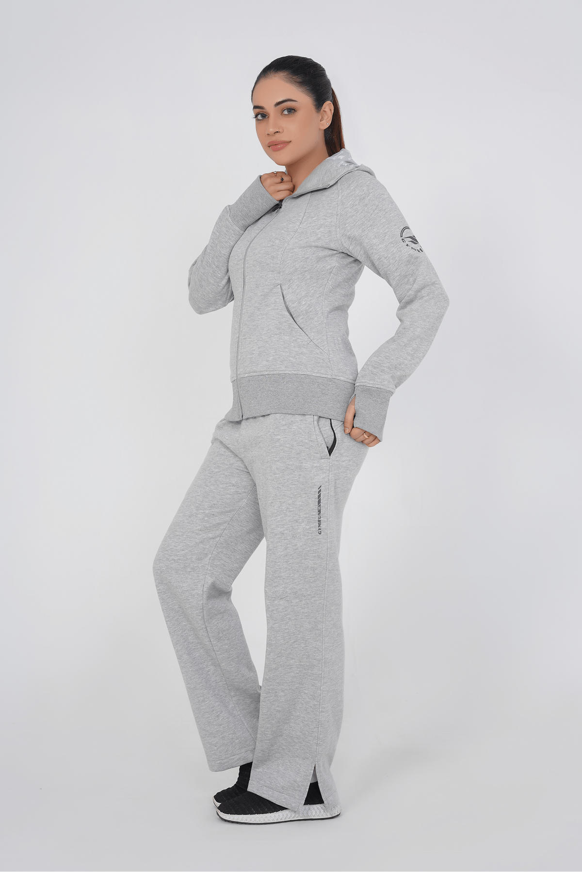 Woman wearing a gray tracksuit on a white background