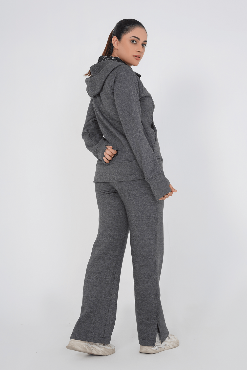 Woman wearing a gray tracksuit on a white background