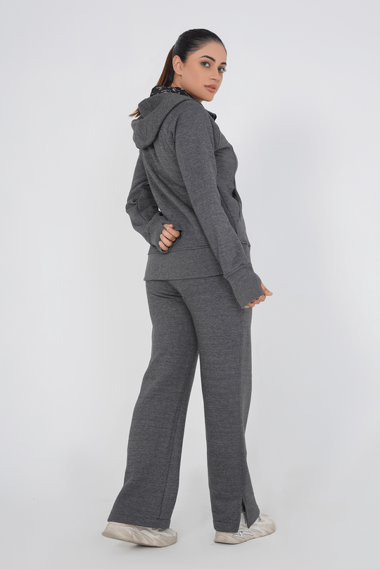 Woman wearing a gray tracksuit on a white background