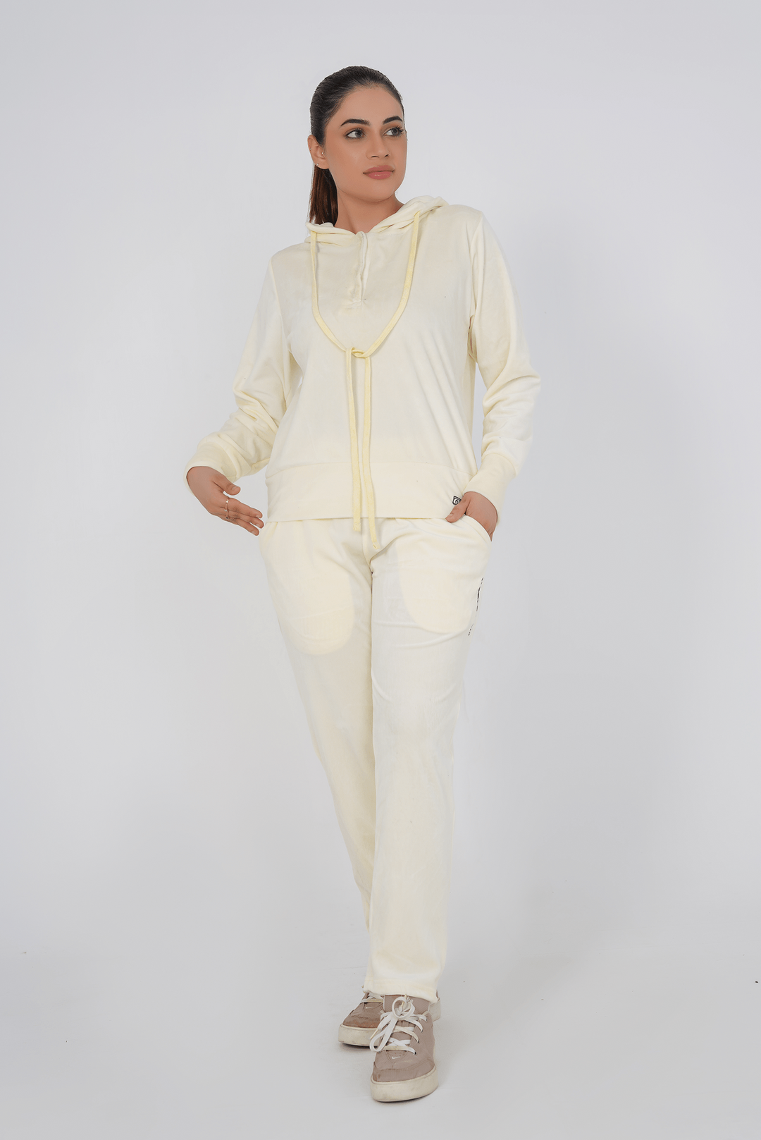 Woman wearing a cream-colored outfit on a white background