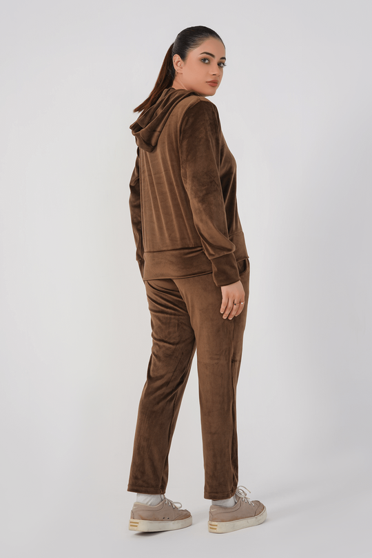 Person wearing a brown corduroy tracksuit on a white background
