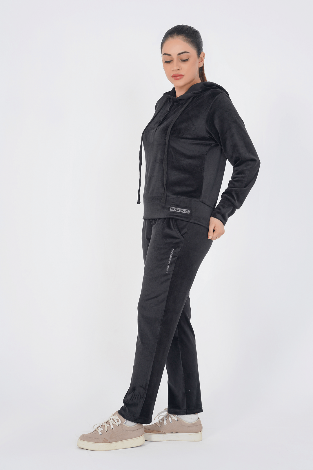 Woman wearing a black tracksuit on a white background