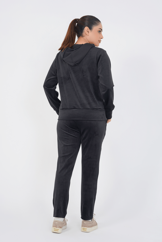 Person wearing a black hoodie and pants set on a white background