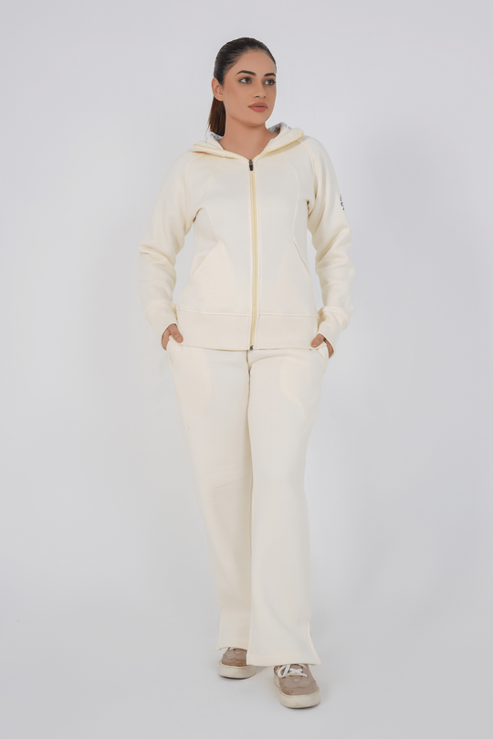 Woman wearing a cream-colored hoodie and pants on a white background