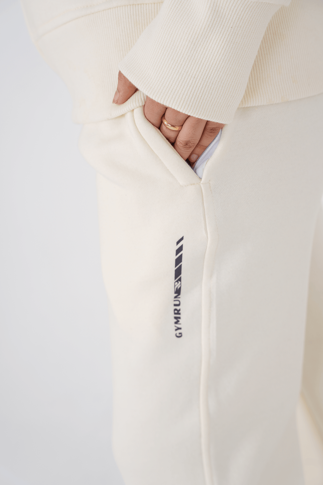 White sweatpants with a logo on the leg against a light background