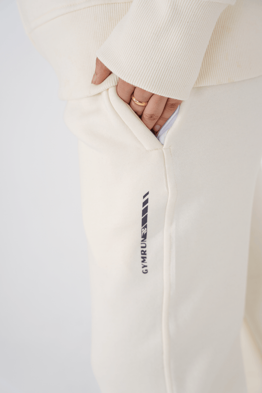 White sweatpants with a logo on the leg against a light background
